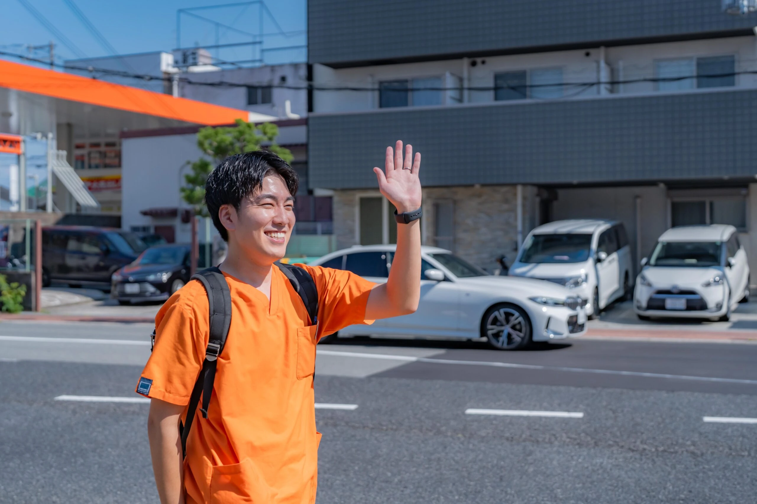屋外で手を振るスタッフ